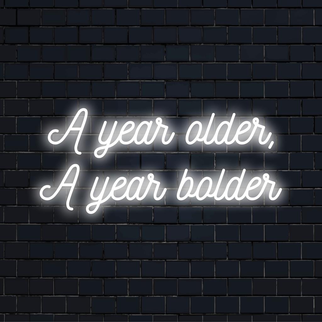 Levendig LED-neonbord met de tekst A Year Older, A Year Bolder als opvallende neonmuurkunst en op maat gemaakte lichtdecoratie.