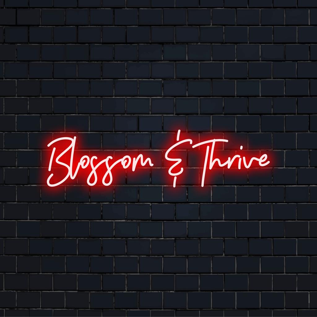 LED-neonbord met 'Blossom And Thrive' in levendige kleuren, perfect voor inspirerende neonkunst en decoratie.
