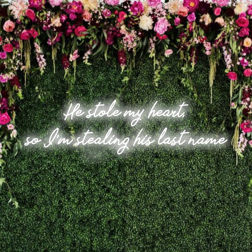 Een op maat gemaakt LED-neonbord met de tekst Hij stal mijn hart, dus ik steel zijn achternaam in een gloeiend neonlichtdecor.