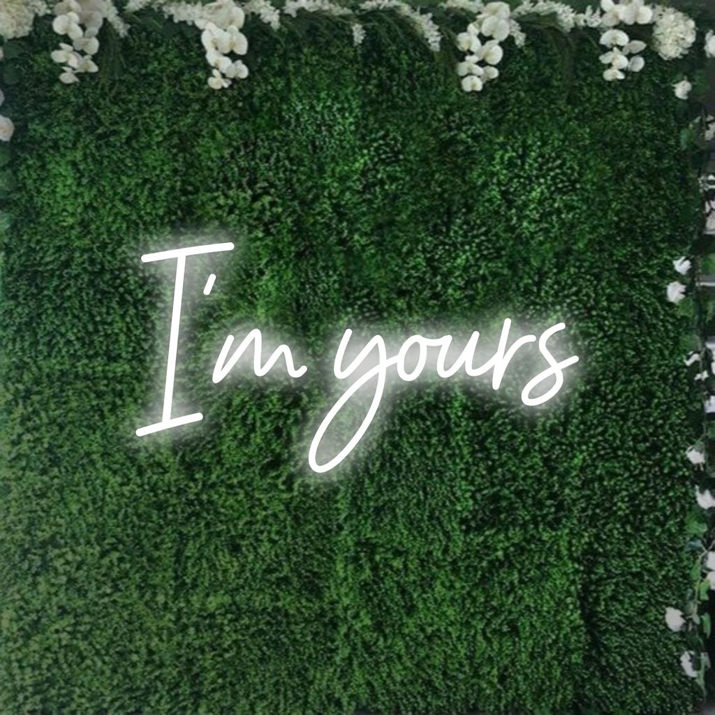 Stijlvol LED-neonbord met 'I'm Yours' in elegant lettertype, dat warm oplicht als aanpasbaar neondecoratiekunstwerk.
