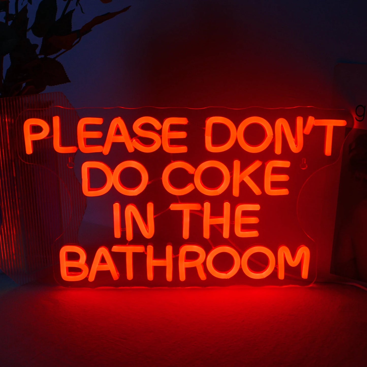 Op de afbeelding is een handgemaakt LED-neonbord te zien met de tekst "Please Don't Do Coke in the Bathroom" in levendige kleuren.