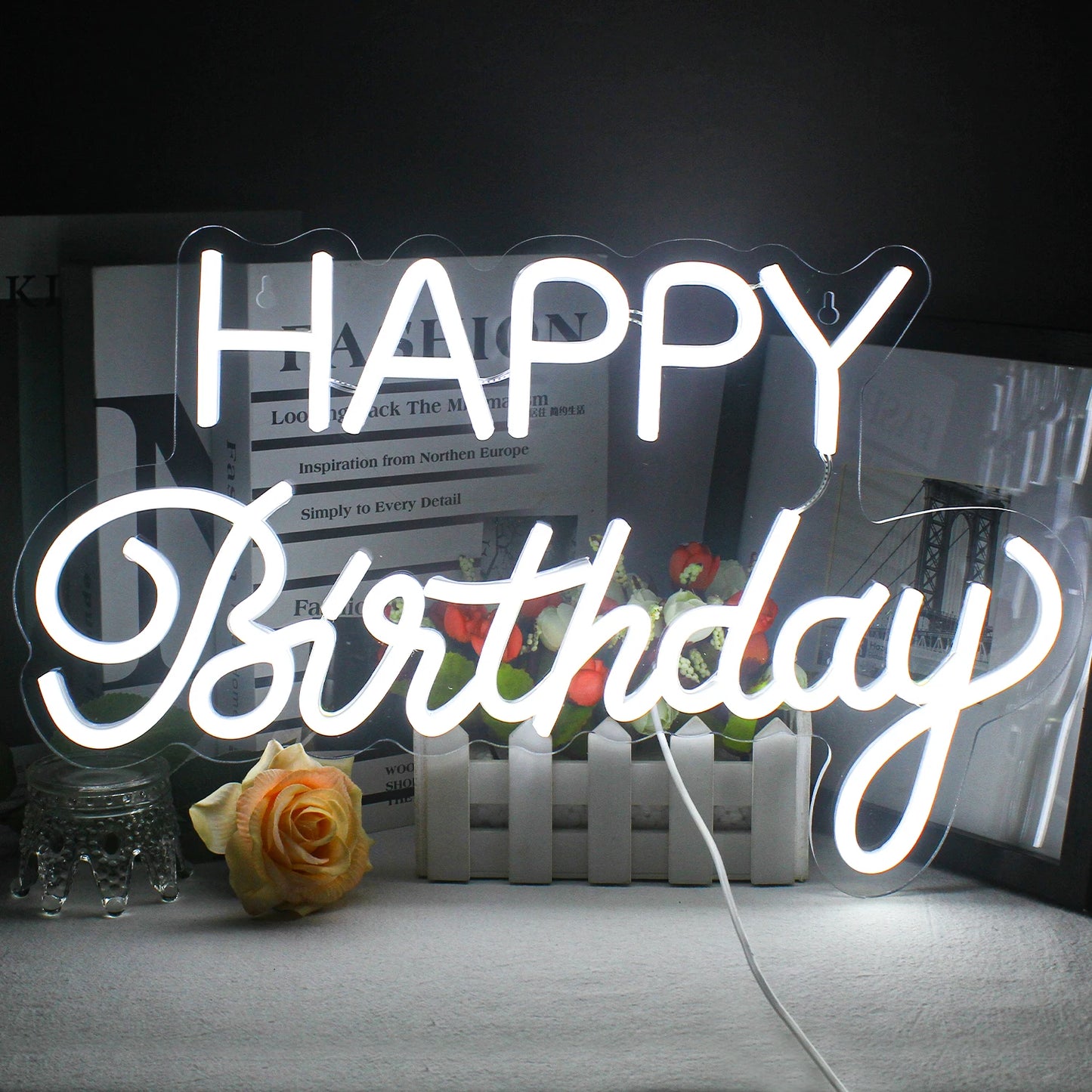 De afbeelding toont een levendig led-neonbord waarop in elegante, cursieve letters de tekst "Happy Birthday" staat.