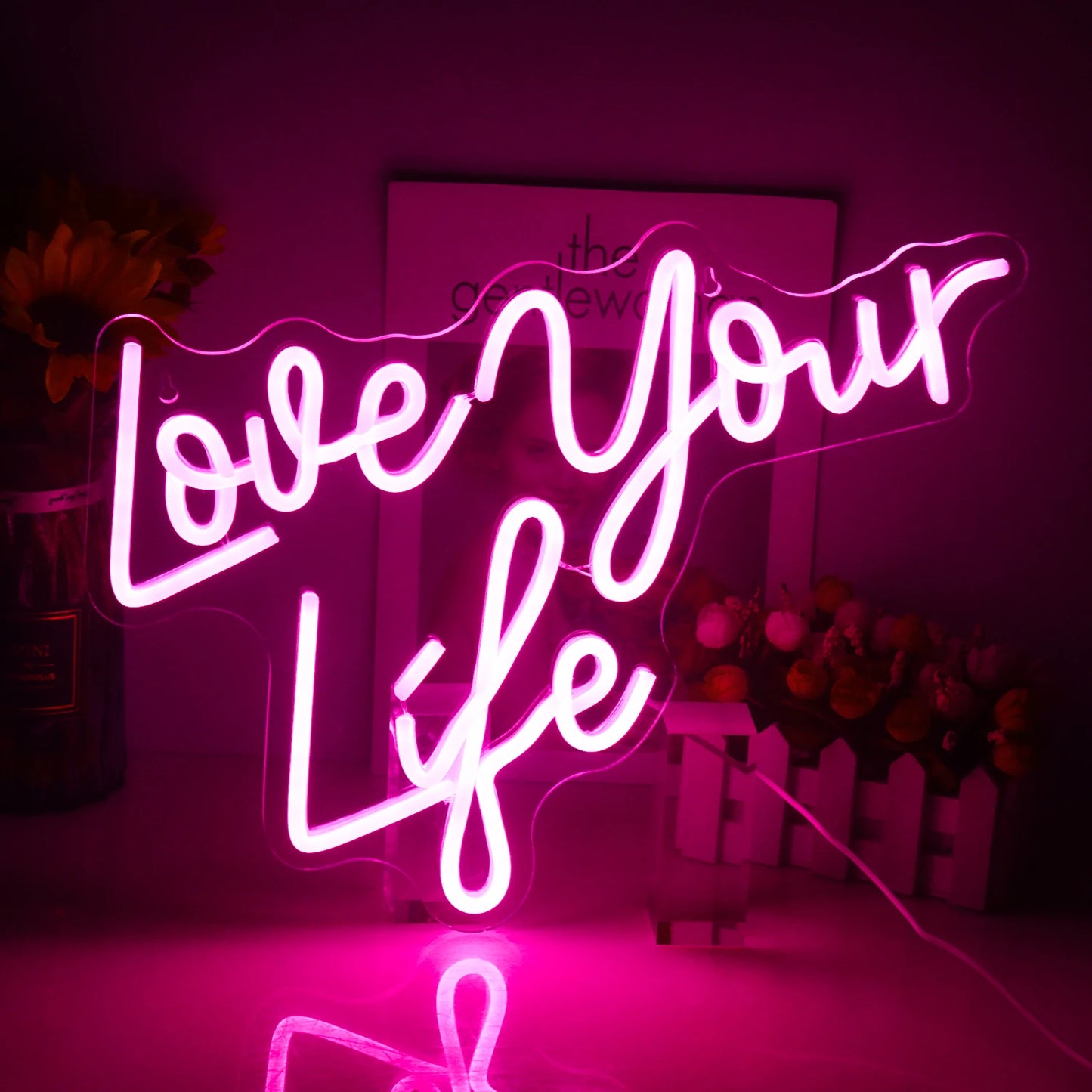 Een felverlicht LED-neonbord met de tekst "Love Your Life" in een stijlvol, cursief schrift.