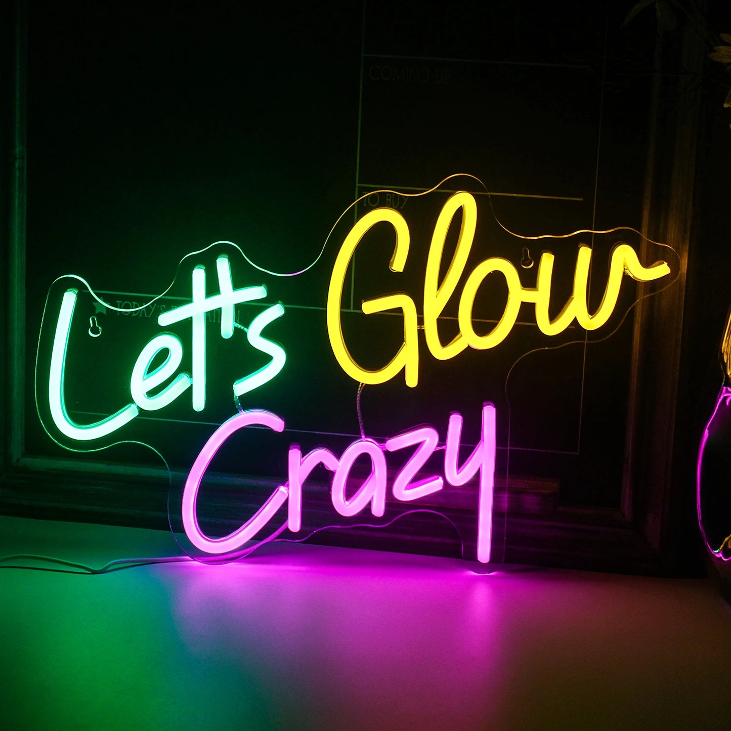 Op de afbeelding staat een levendig, handgemaakt LED-neonbord met de tekst 'Let's Glow Crazy'.