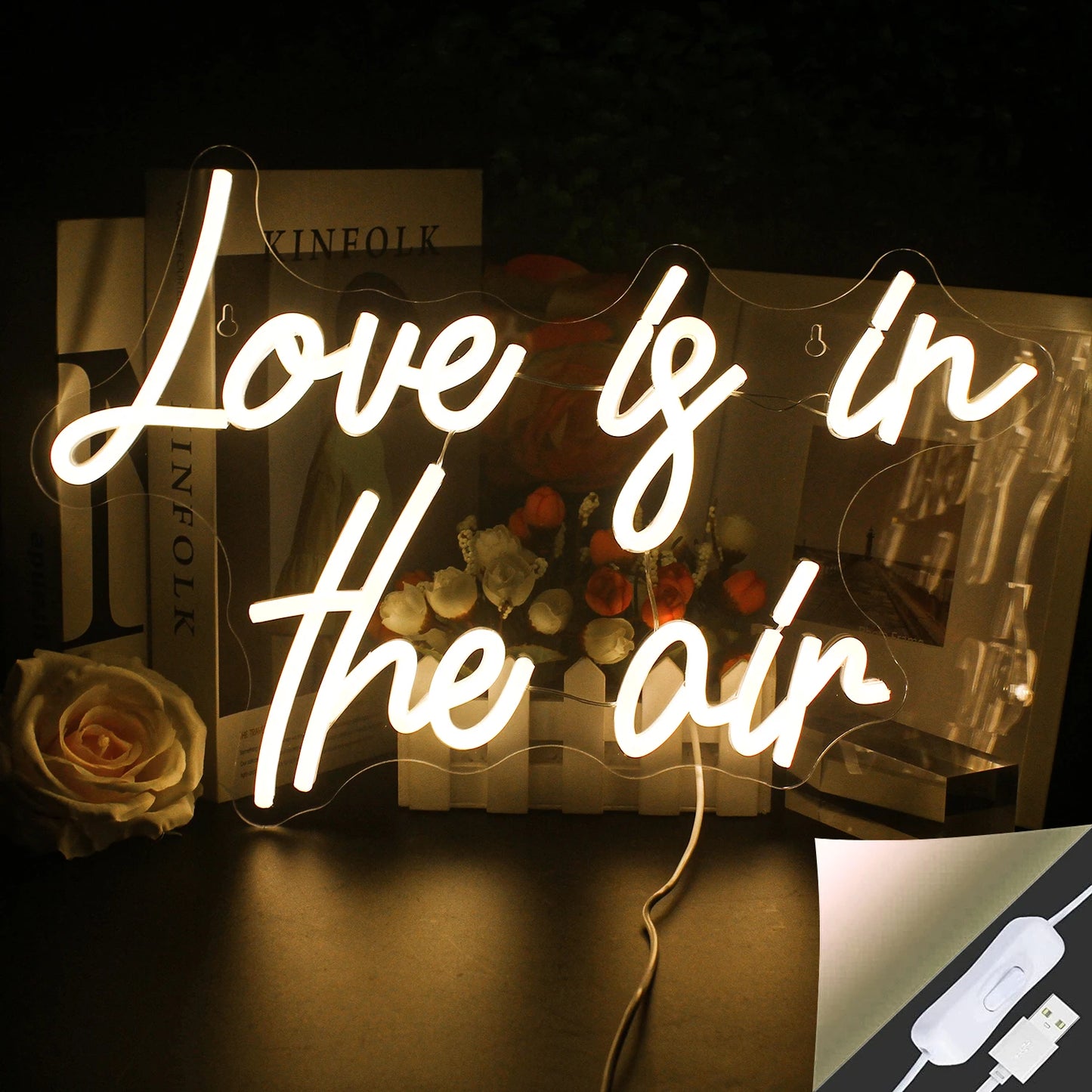 De afbeelding toont een levendig en stijlvol LED-neonbord met de tekst "Love is in the Air" in sierlijk, cursief schrift.