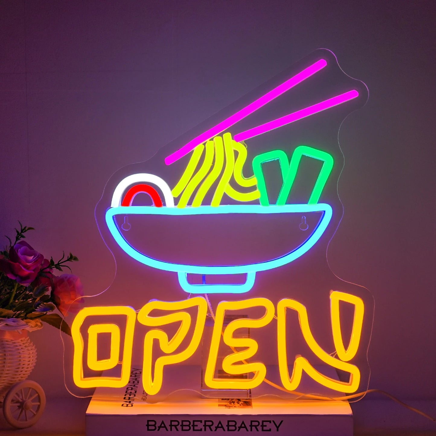Op de afbeelding is een opvallend led-neonbord te zien met de tekst "Open Ramen" in opvallende, gloeiende kleuren.