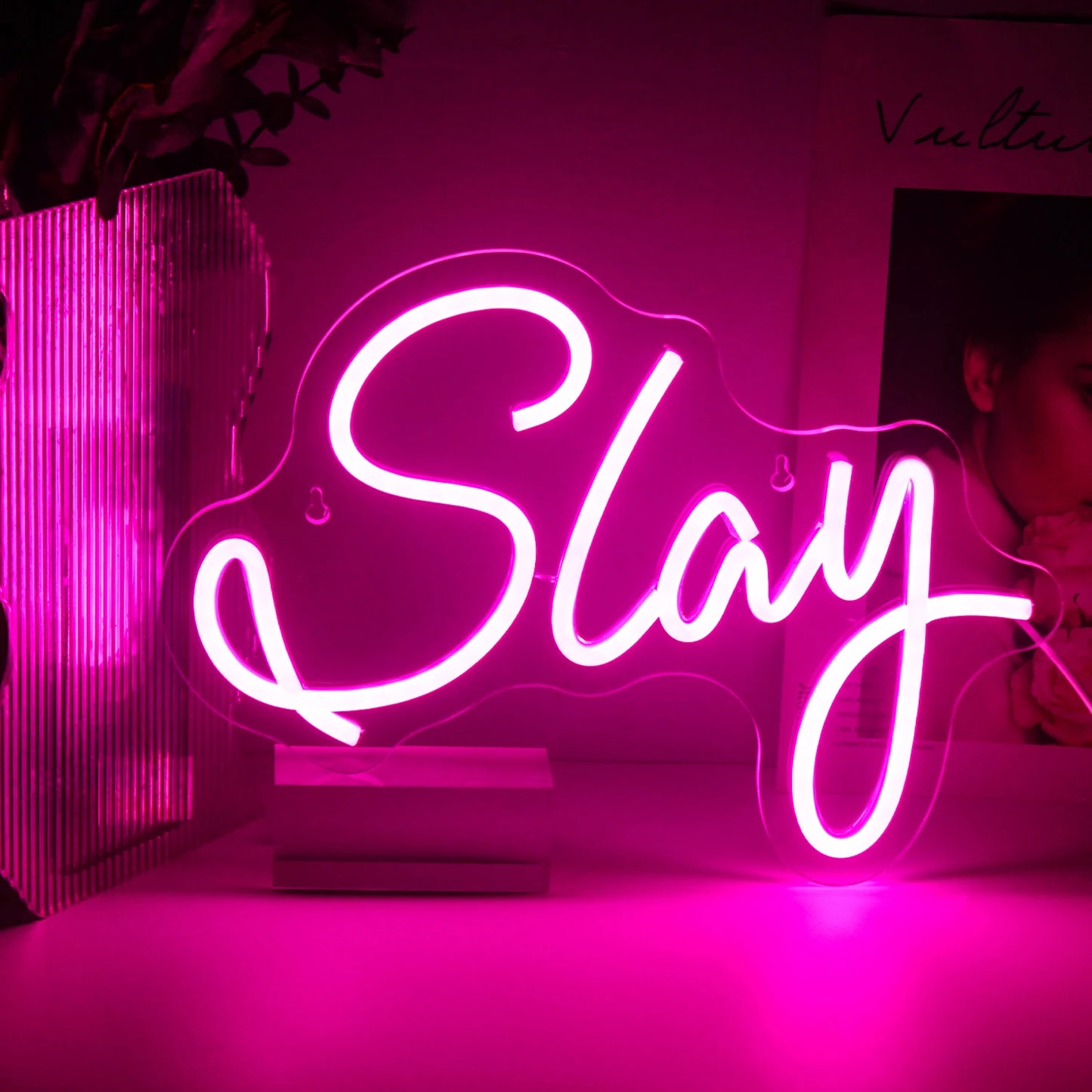 De afbeelding toont een levendig, handgemaakt LED-neonbord met het woord "Slay" in een stijlvol, cursief lettertype.