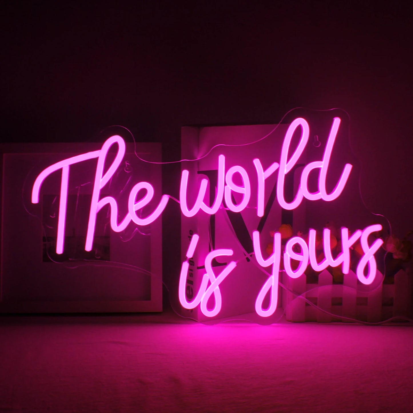 Een levendig LED-neonbord met de tekst "The World Is Yours" in een stijlvol, cursief lettertype.
