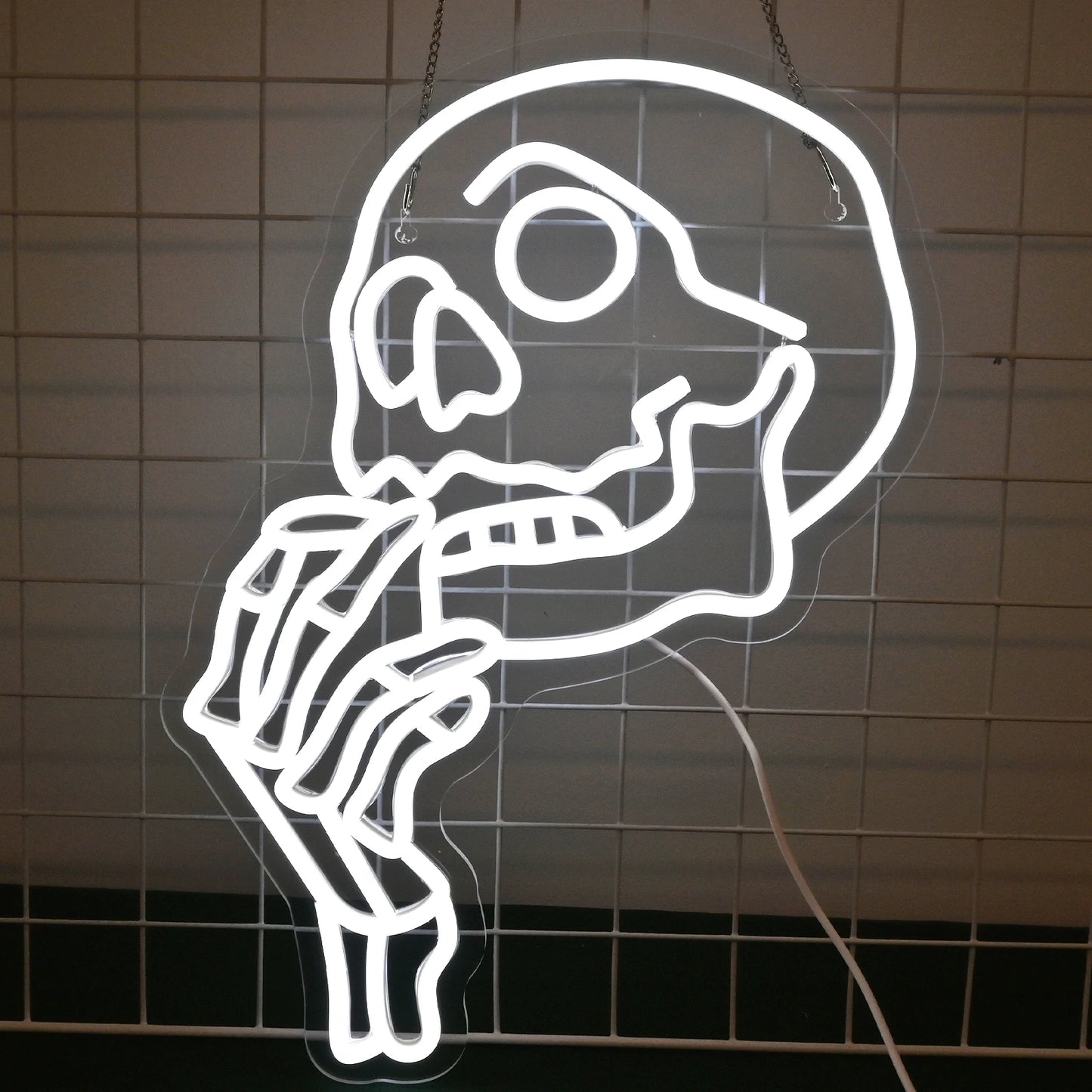 De afbeelding toont een levendig, handgemaakt LED-neonbord in de vorm van een schedel.