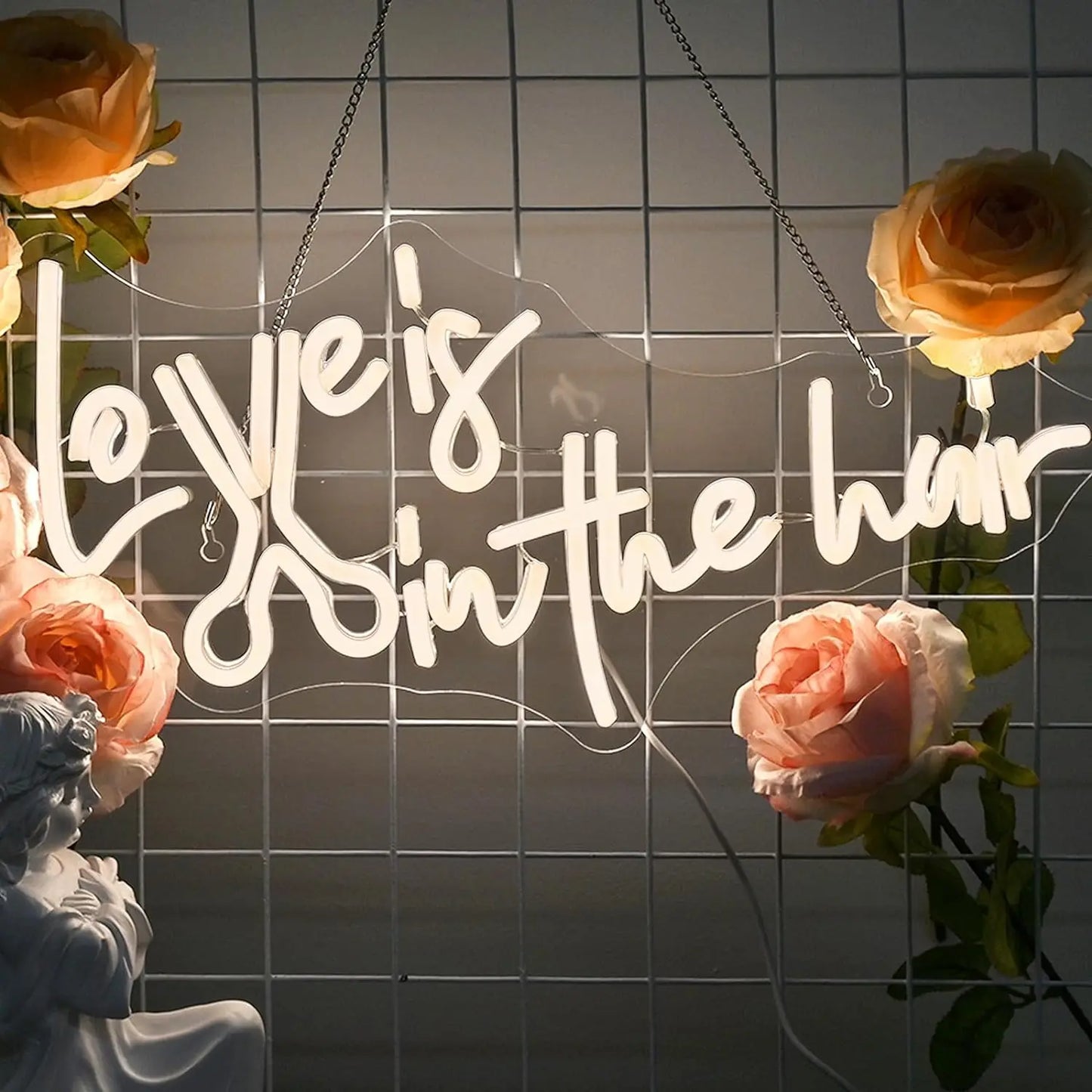 Op de afbeelding staat een levendig, handgemaakt LED-neonbord met de tekst 'Love is in the Hair'.