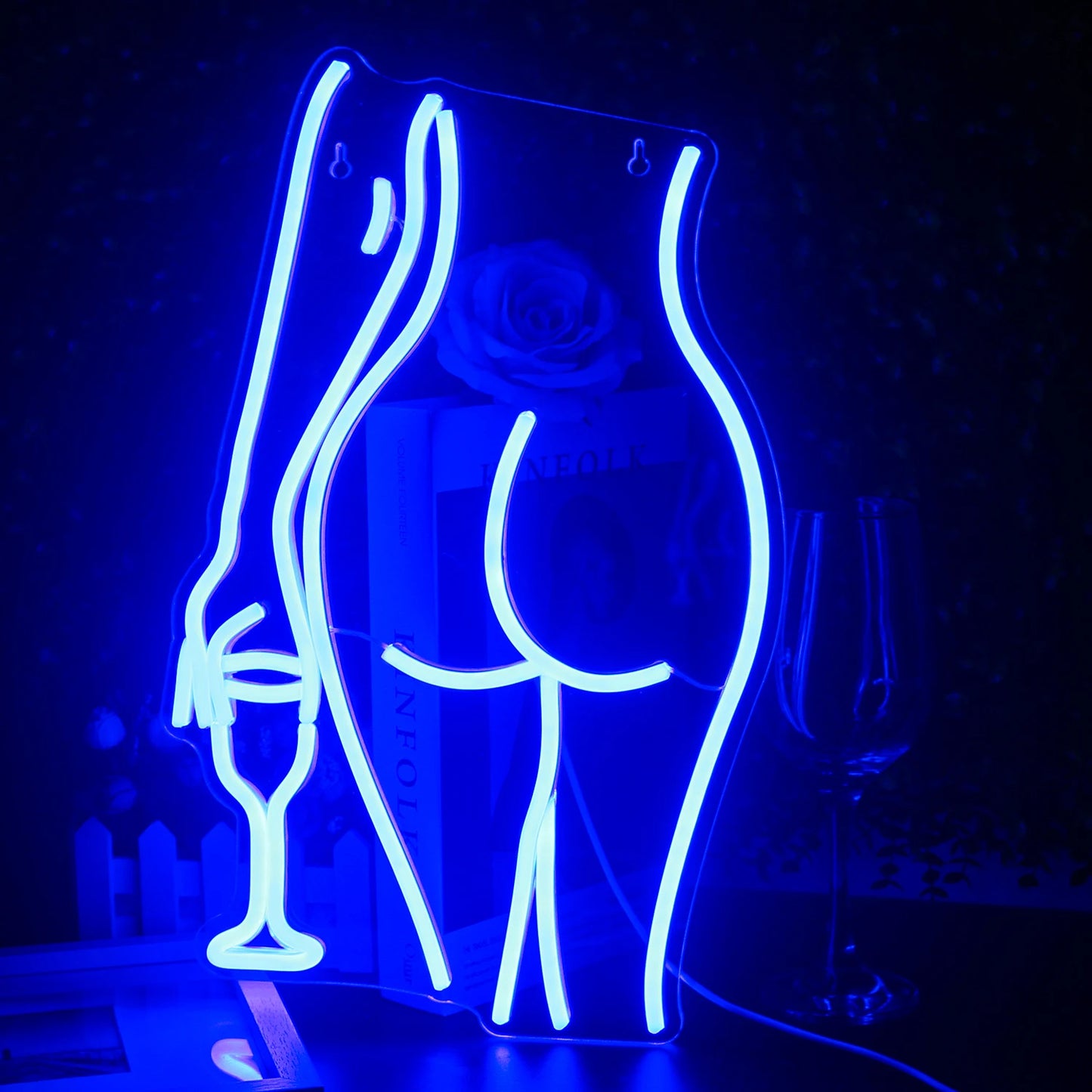 Een levendig, handgemaakt LED-neonbord in de vorm van het silhouet van een liggende vrouw.
