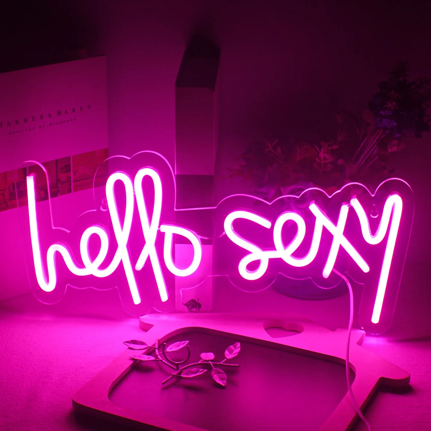 Op de afbeelding staat een levendig "Hello Sexy" LED-neonbord.