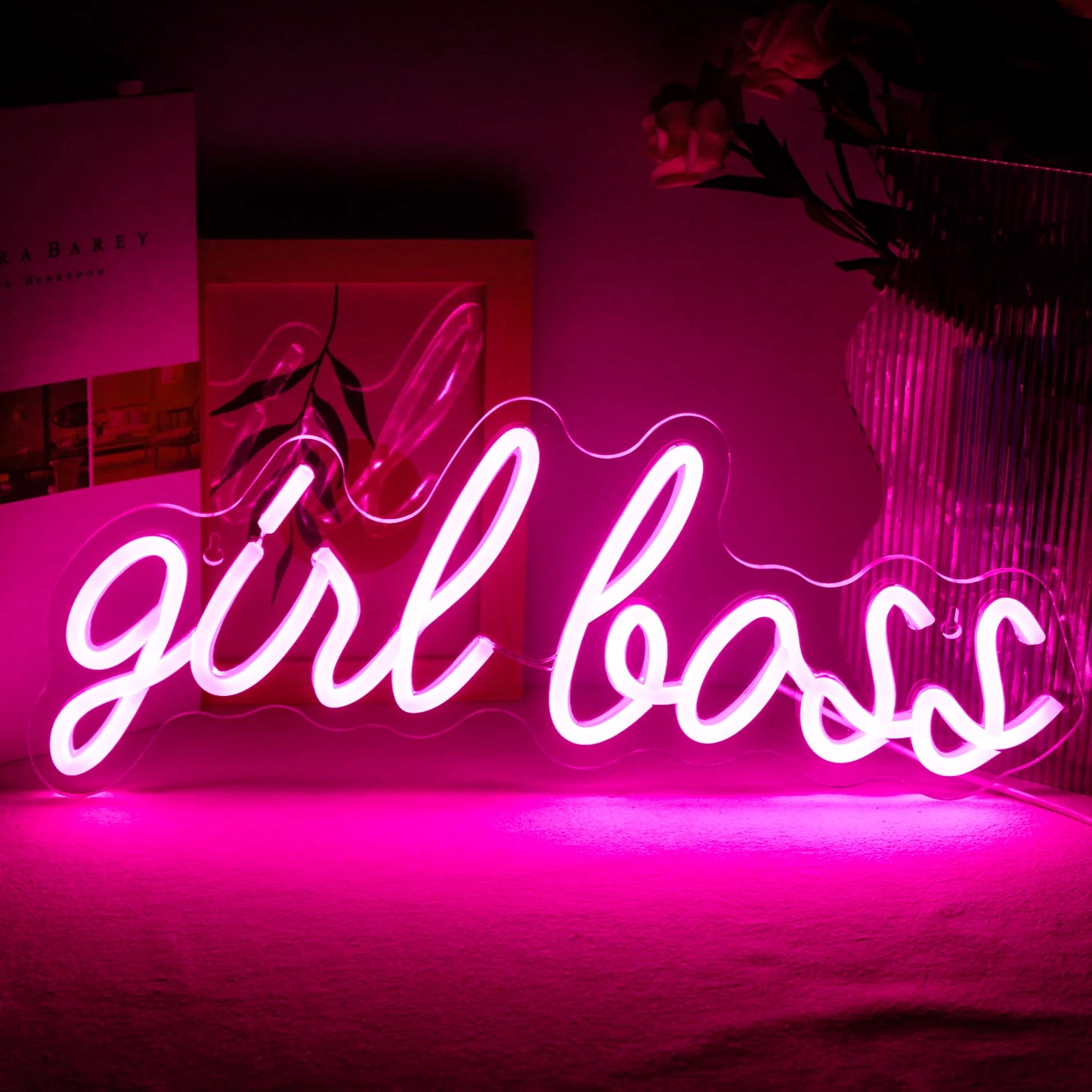 Op de afbeelding staat een levendig, handgemaakt LED-neonbord waarop de tekst "Girl Boss" in een stijlvol, cursief lettertype staat.
