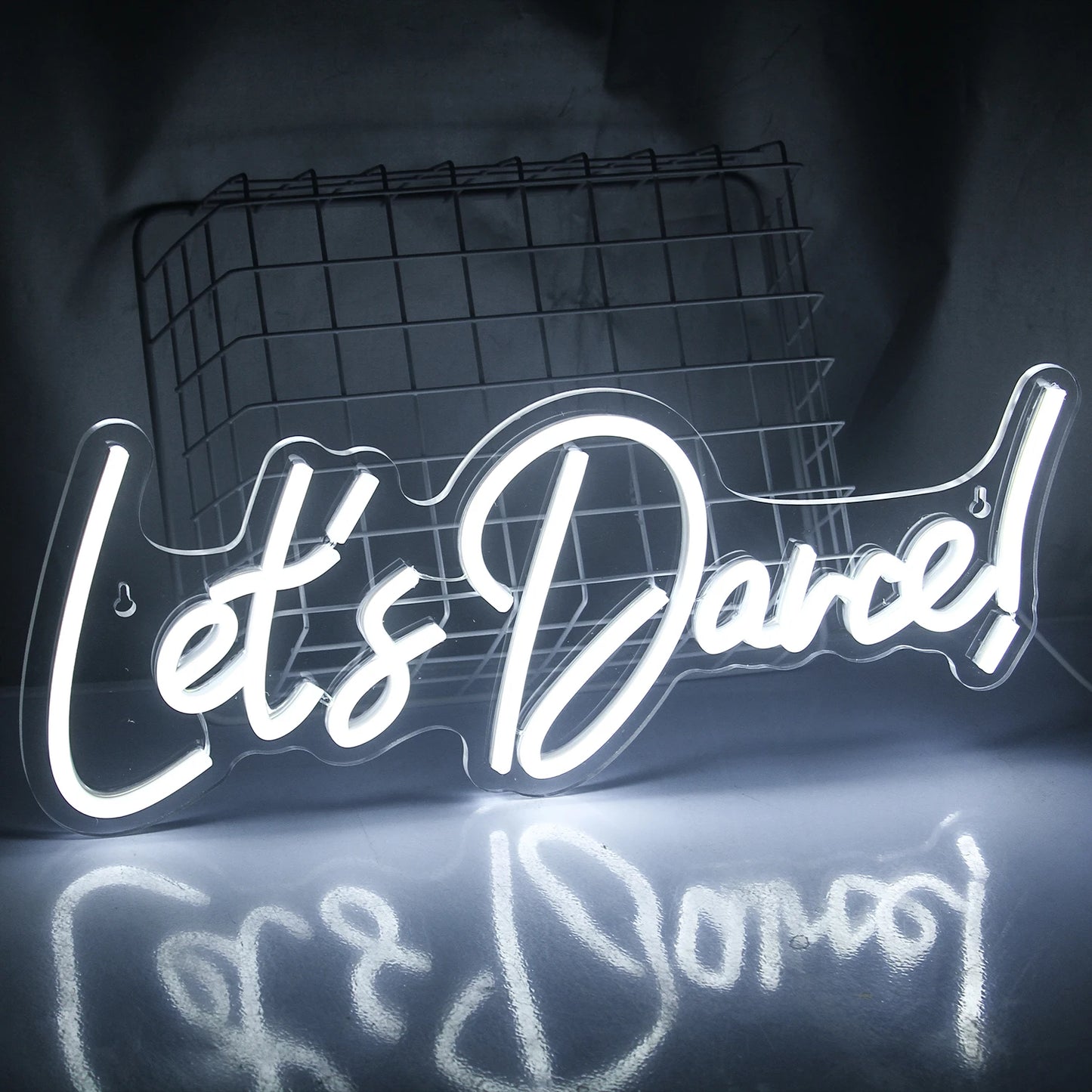 Een felverlicht "Let's Dance" LED-neonbord in levendige roze en blauwe kleuren.