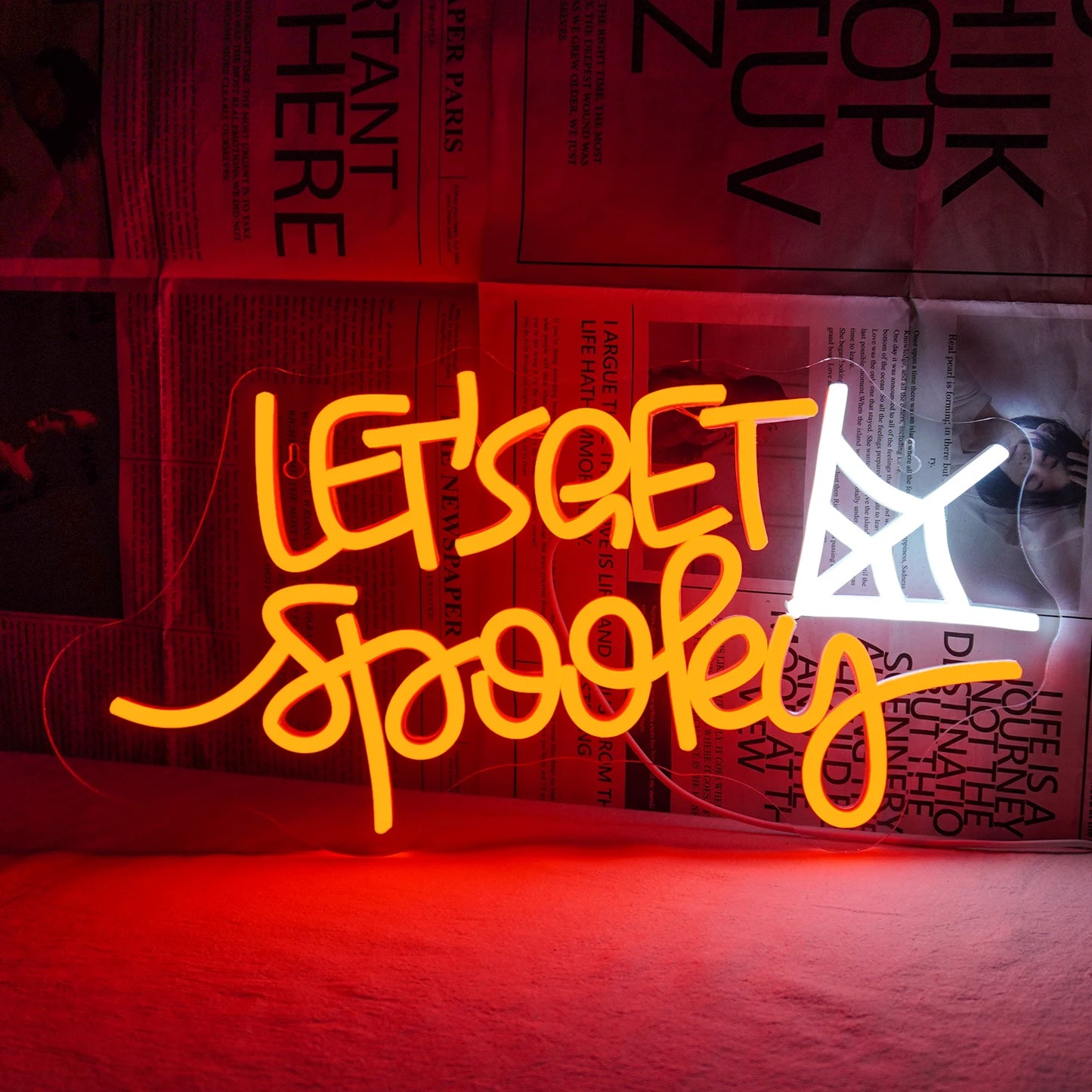 Op de afbeelding is een levendig LED-neonbord te zien met de tekst "Let's Get Spooky" in een speels, golvend lettertype.