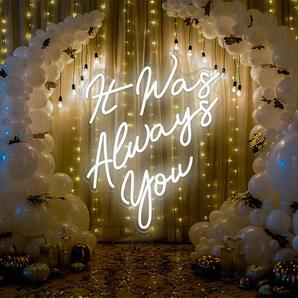 Een levendig LED-neonbord met de tekst "It Was Always You" in elegant, vloeiend, cursief schrift.