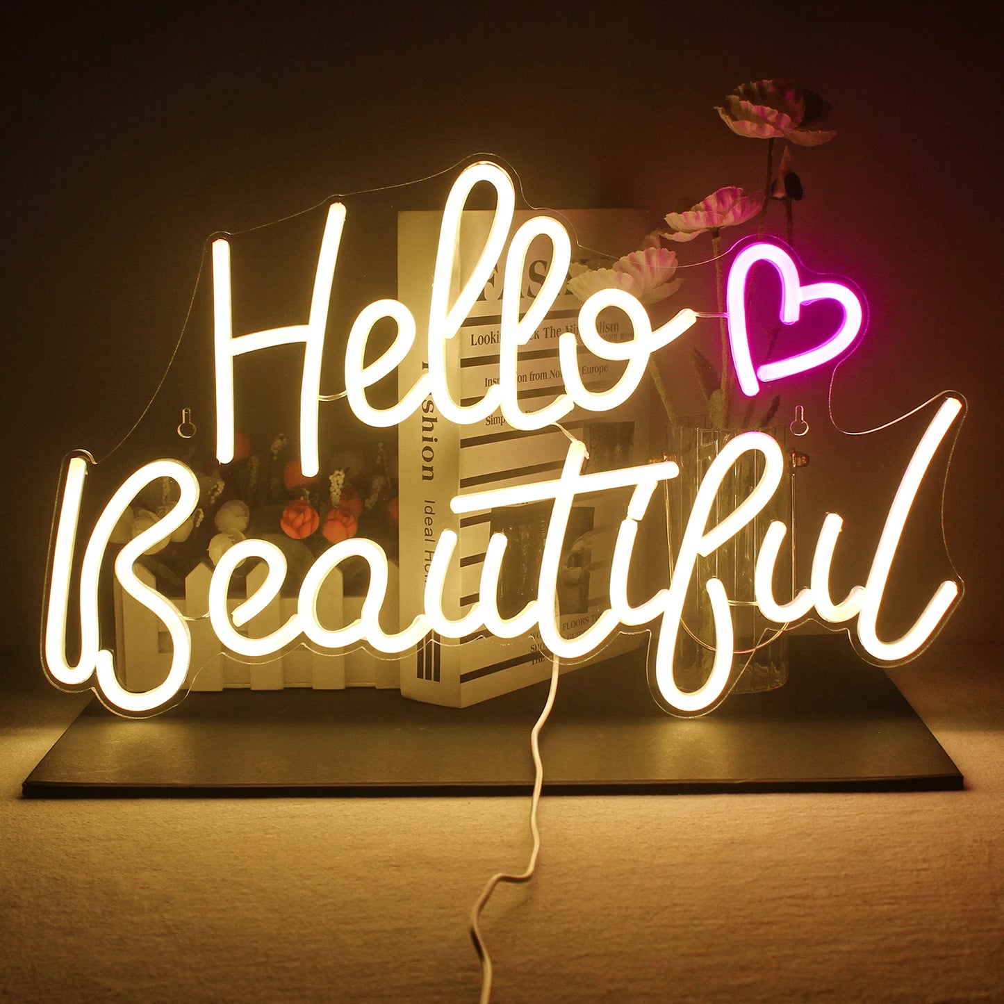 De afbeelding toont een levendig, handgemaakt LED-neonbord met de tekst "Hello Beautiful" in een speels, cursief lettertype.