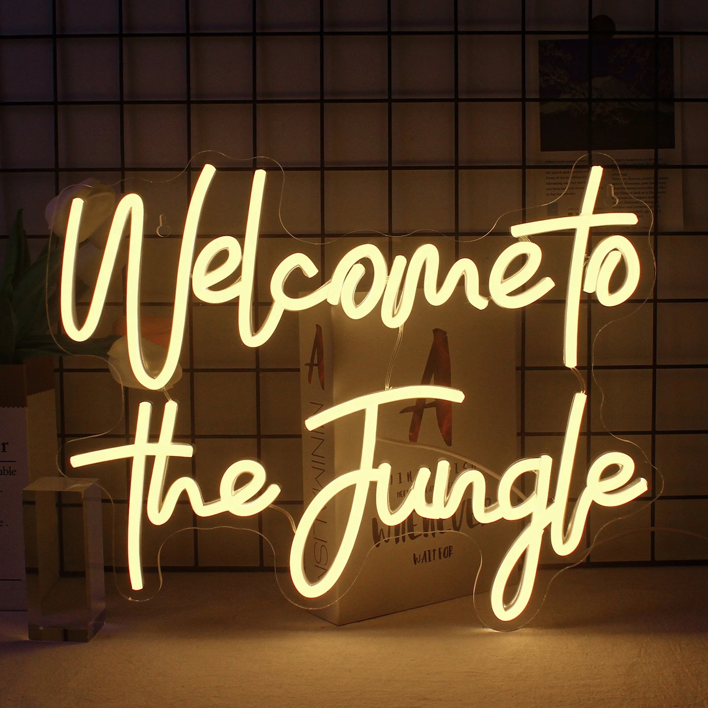 Een levendig LED-neonbord met de tekst "Welcome to the Jungle" in opvallende, cursieve letters.