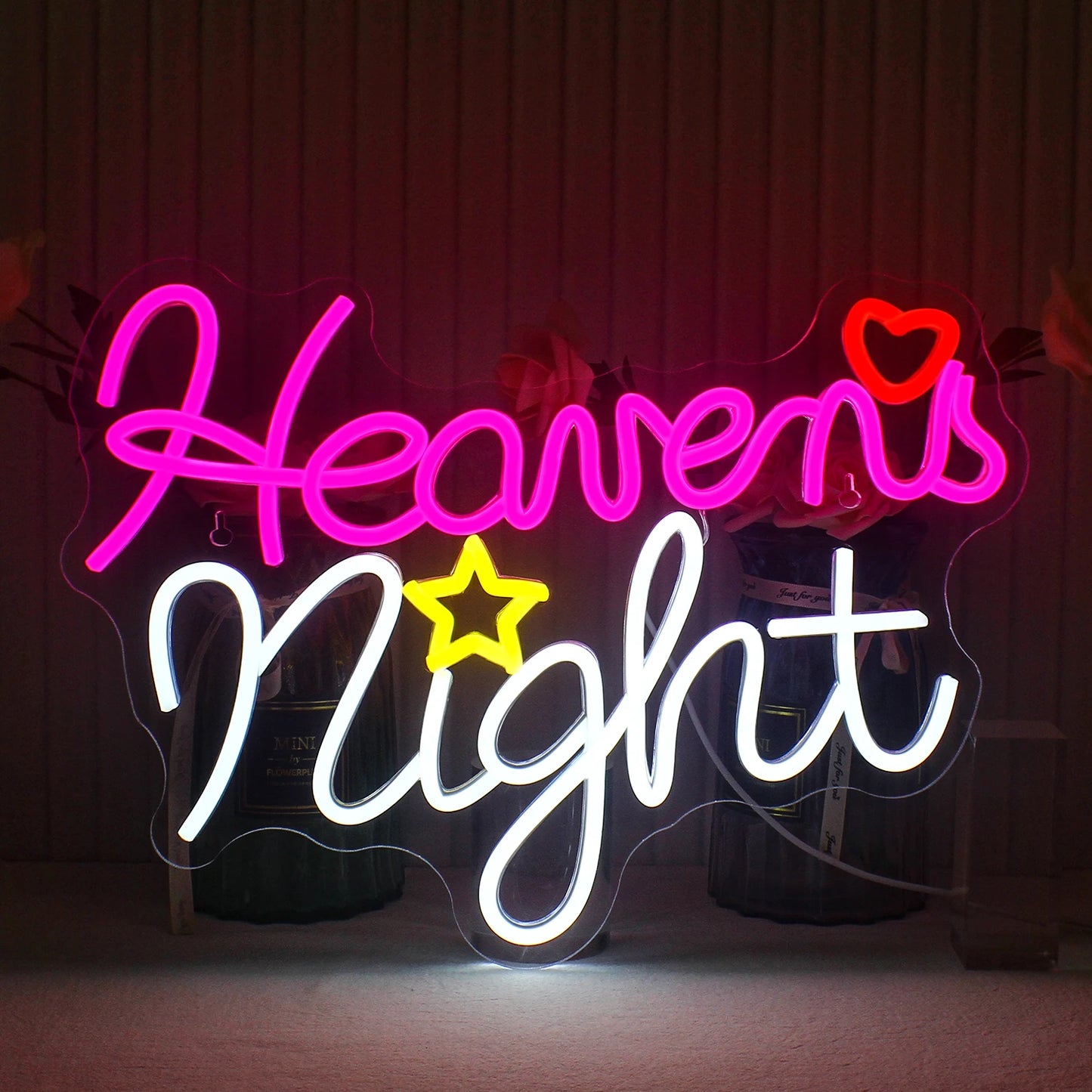 De afbeelding toont een handgemaakt LED-neonbord met de tekst 'Heavens Night' in elegante, cursieve letters.