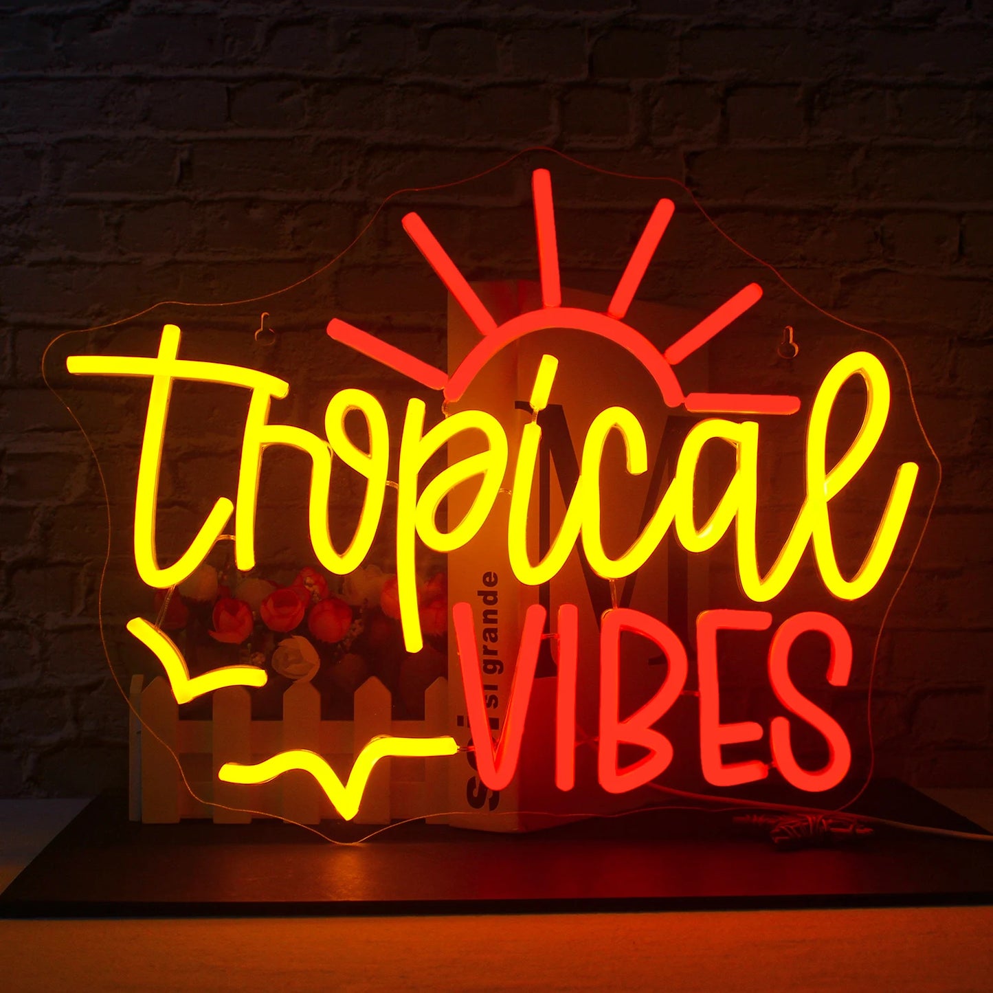 Een afbeelding van een oplichtend LED-neonbord waarop in levendige kleuren de tekst "Tropical Vibes" staat.