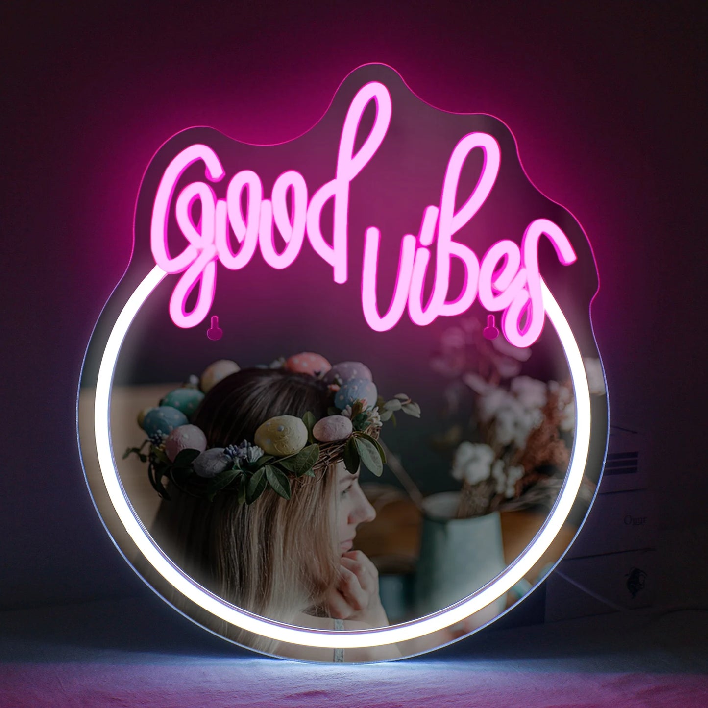 Op de afbeelding is een stijlvol LED-neonbord te zien waarop in levendige, oplichtende roze letters de tekst 'Good Vibes' staat.