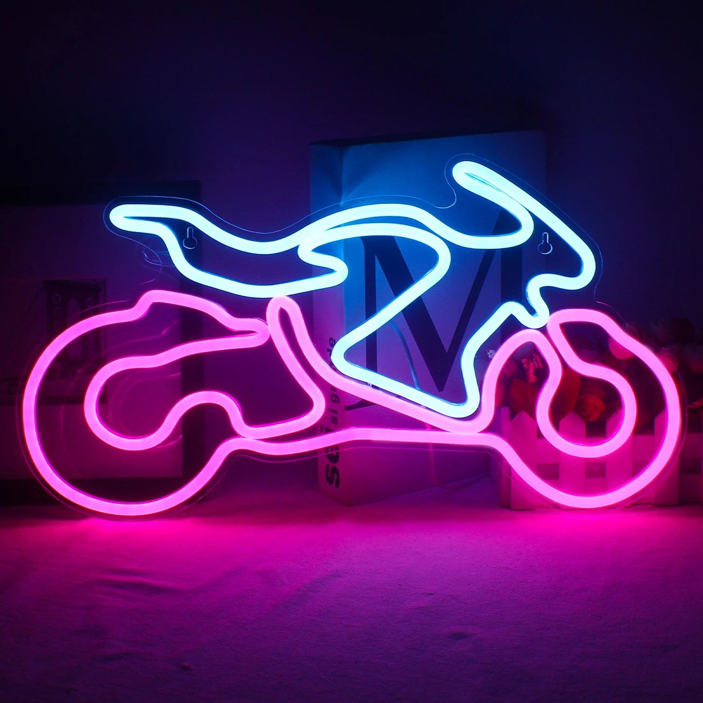 De afbeelding toont een levendig LED-neonbord in de vorm van een motorfiets, met de omtrek van een klassieke motorfiets.