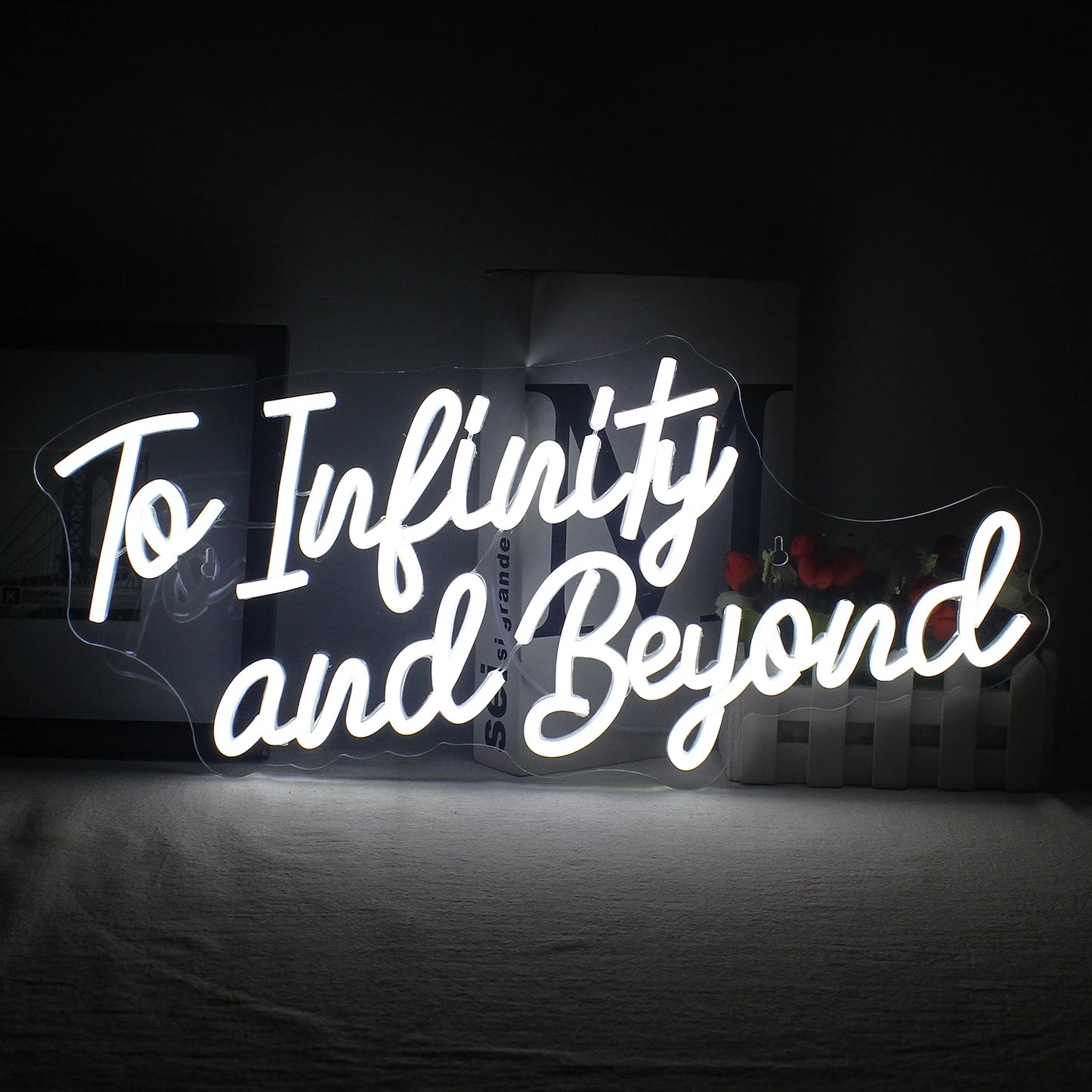 Op de afbeelding is een handgemaakt LED-neonbord te zien met de tekst "To Infinity and Beyond" in levendige, oplichtende letters.