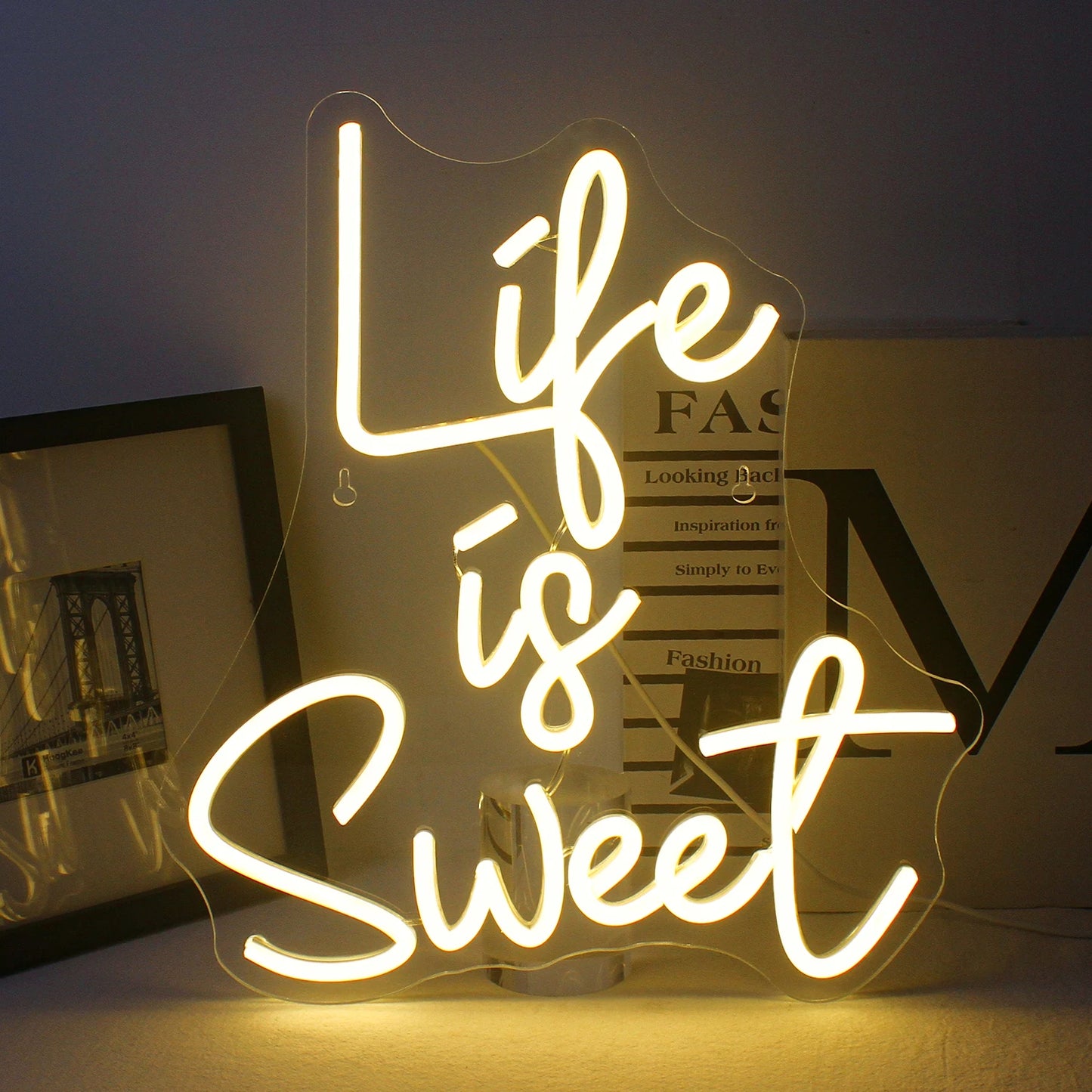 Op de afbeelding staat een levendig, handgemaakt LED-neonbord in felle, gloeiende kleuren met de tekst: "Life is Sweet.