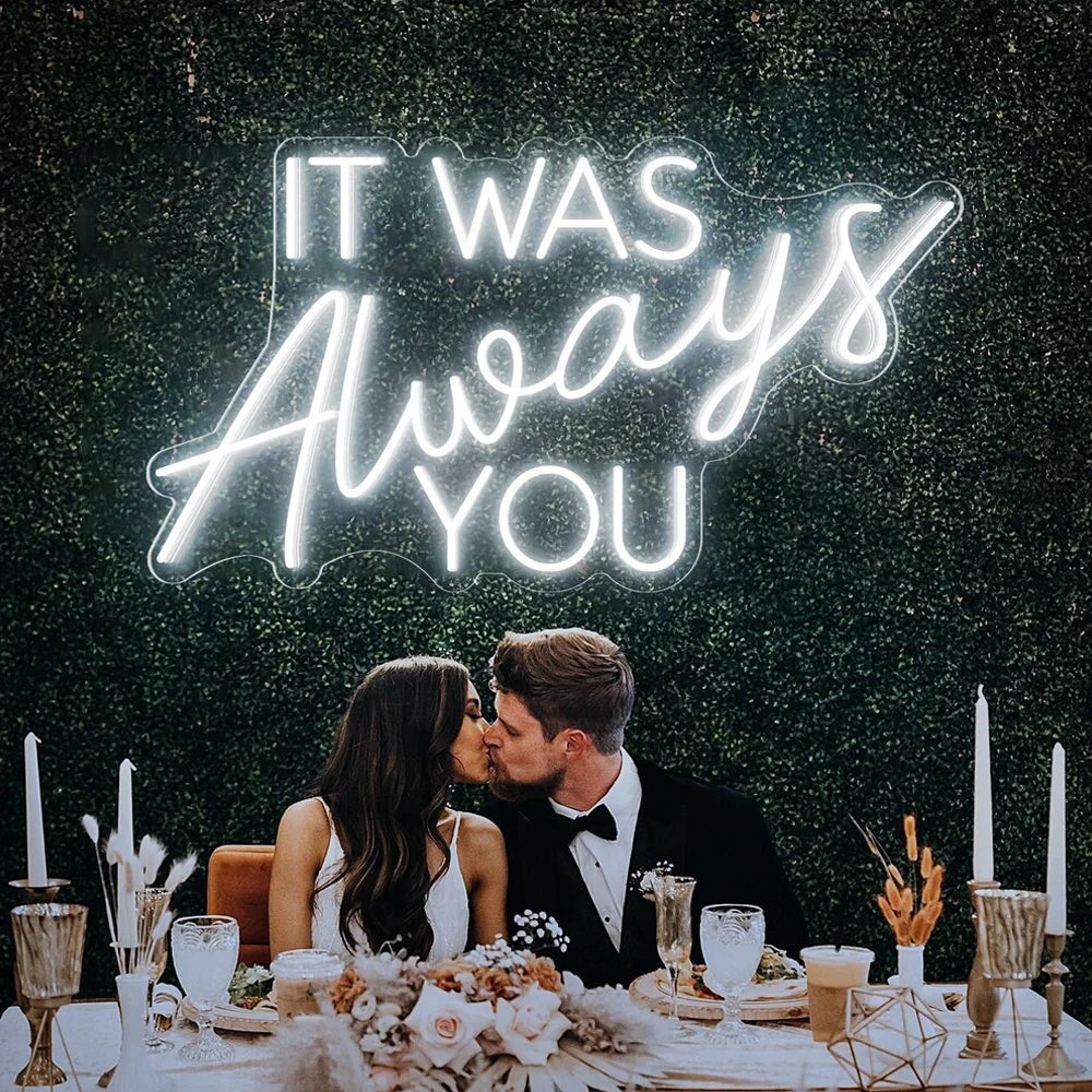 Op de afbeelding staat een handgemaakt LED-neonbord met de tekst "It Was Always You" in een elegant, vloeiend lettertype.