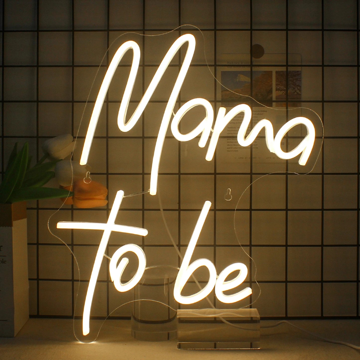 De afbeelding toont een levendig en stijlvol LED-neonbord met de tekst "Mama to Be" in elegante, cursieve letters.