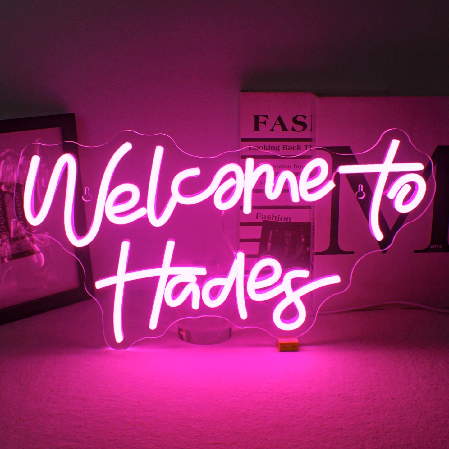 Een led-neonbord met de tekst "Welcome to Hades" in fel, gloeiend neonlicht.