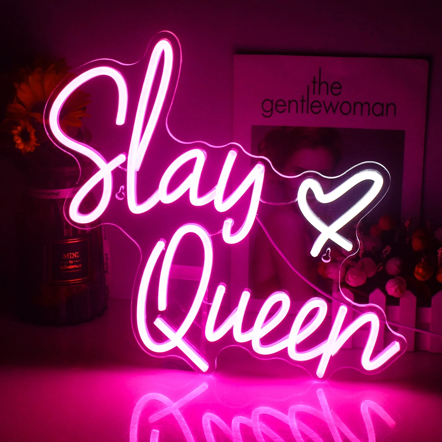 Op de afbeelding staat een opvallend LED-neonbord met de tekst "Slay Queen" in elegante, cursieve letters.