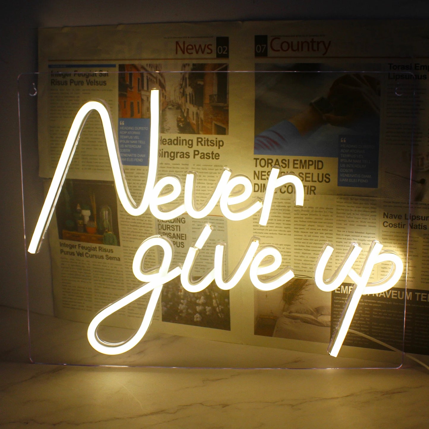 Op de afbeelding staat een opvallend led-neonbord met de motiverende zin "Never Give Up" in vette, cursieve letters.