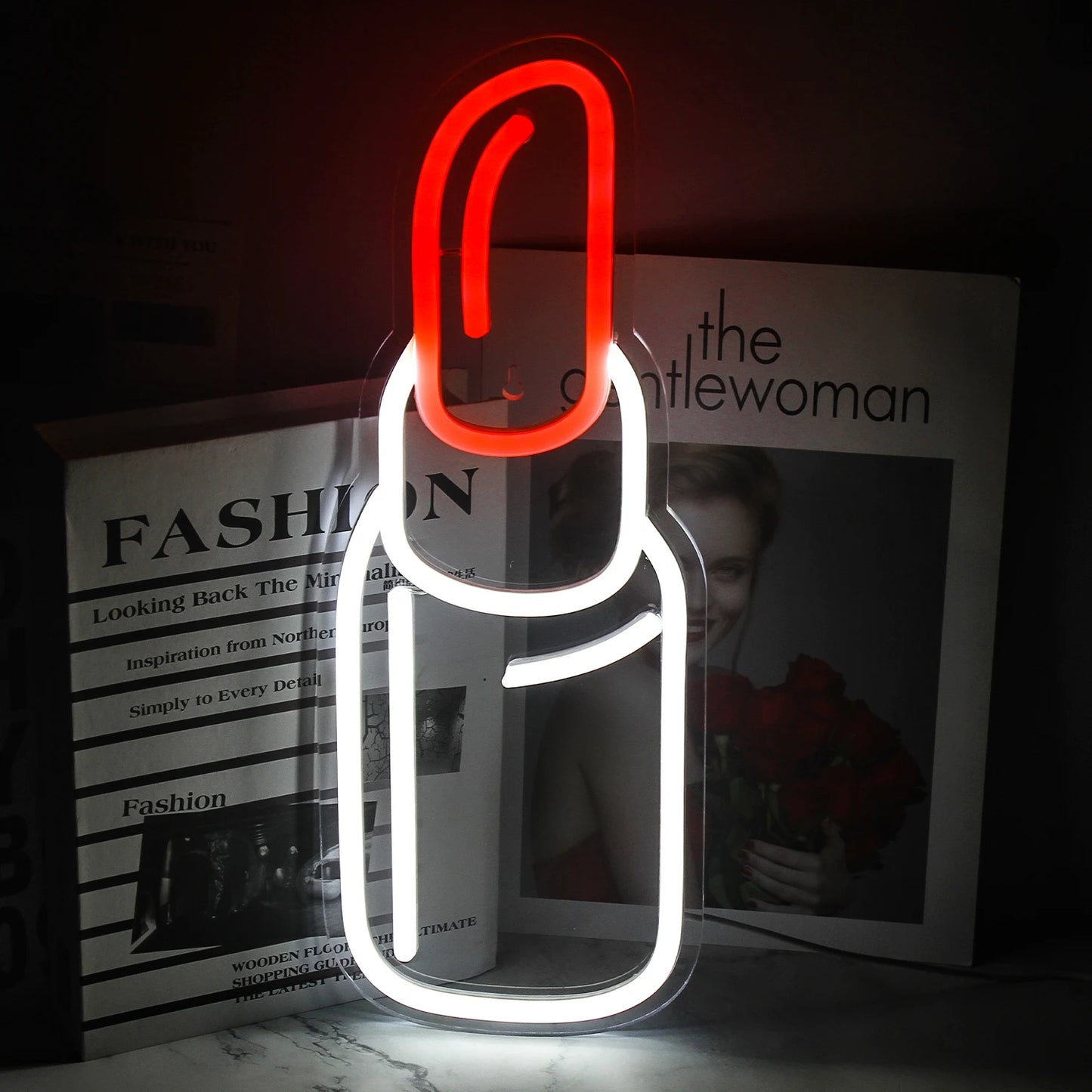 Op de afbeelding is een levendig, handgemaakt LED-neonreclamescherm te zien in de vorm van een lippenstift.
