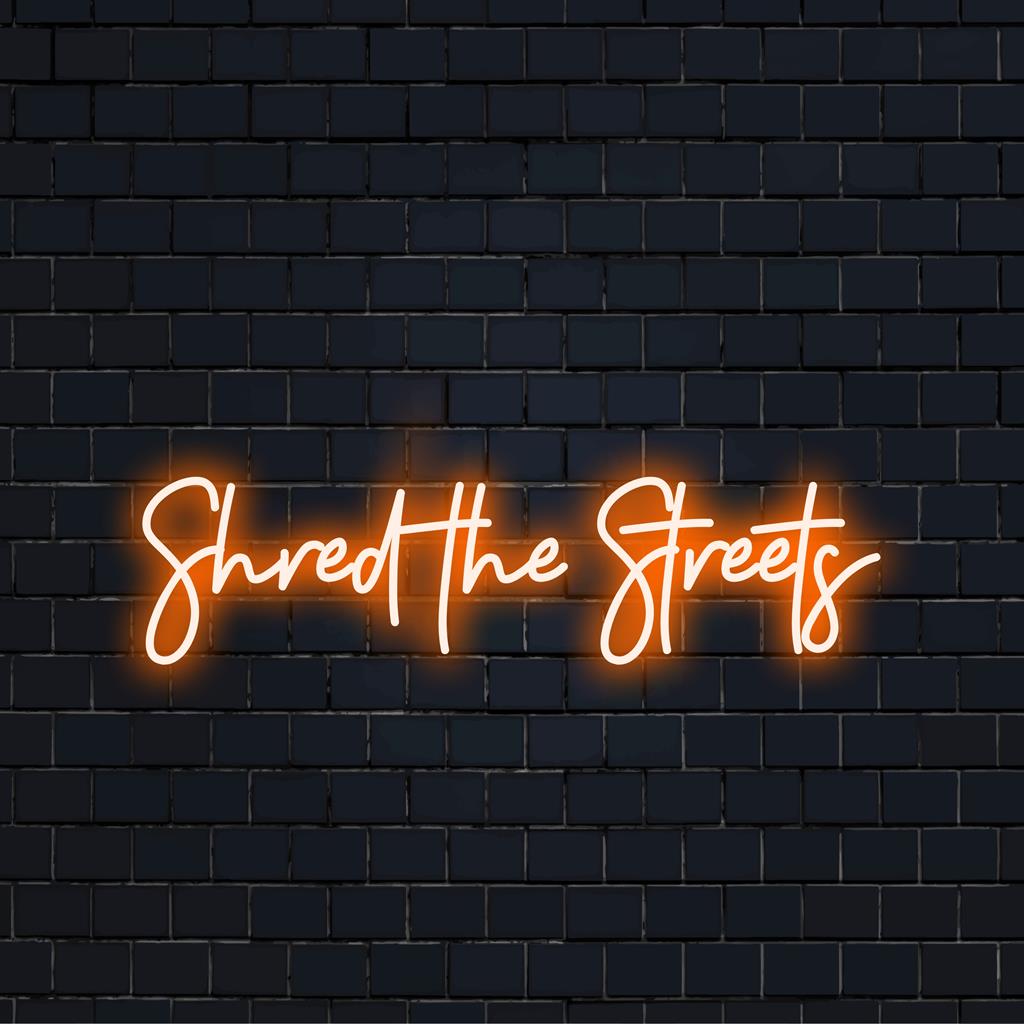 Speciaal ontworpen LED-neonreclame met de tekst 'Shred The Streets' in levendige kleuren. Perfecte neondecoratie voor elke moderne ruimte.
