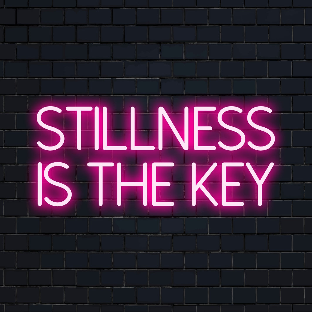 Een op maat gemaakt LED-neonbord met de tekst Stillness Is the Key, perfect voor gepersonaliseerde neonkunst aan de muur of inspirerende decoratie.