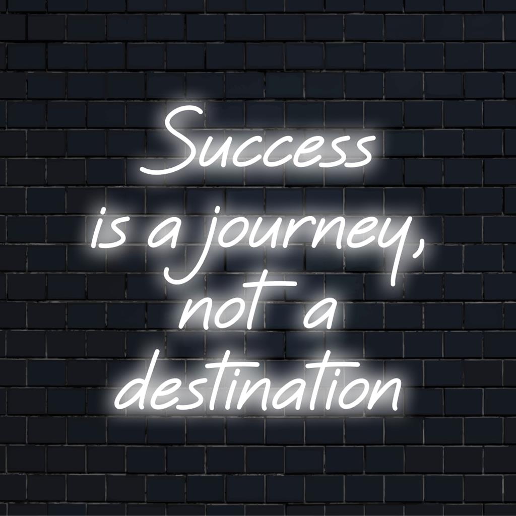 Aangepast LED-neonbord met de tekst Success Is A Journey, Not A Destination in felle, artistieke neontypografie.