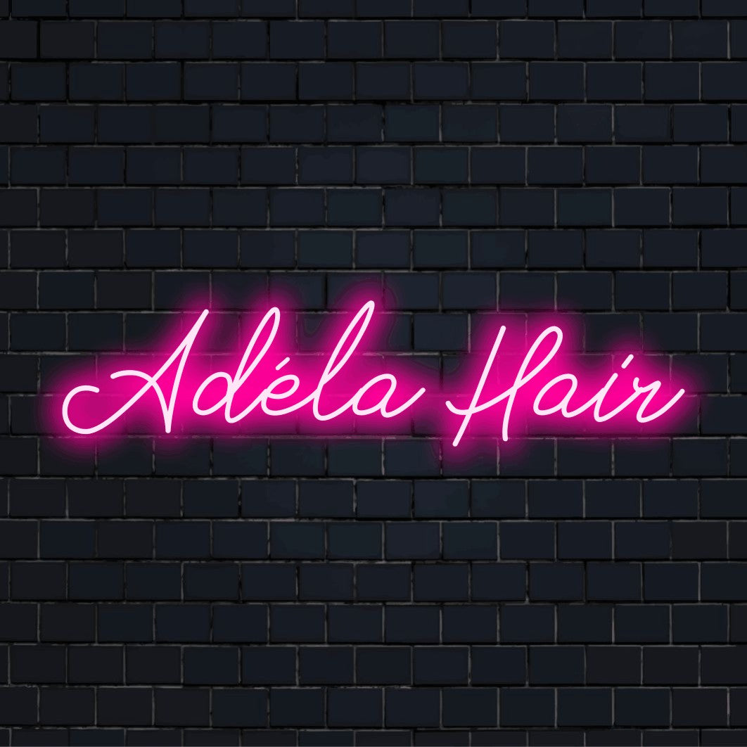 Adela Hair Custom Name Neon Sign, bright neon lettering on dark brick wall