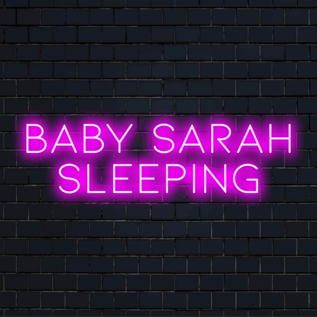 Baby Sarah Sleeping Custom Name Neon Sign, soft neon glow against black brick wall