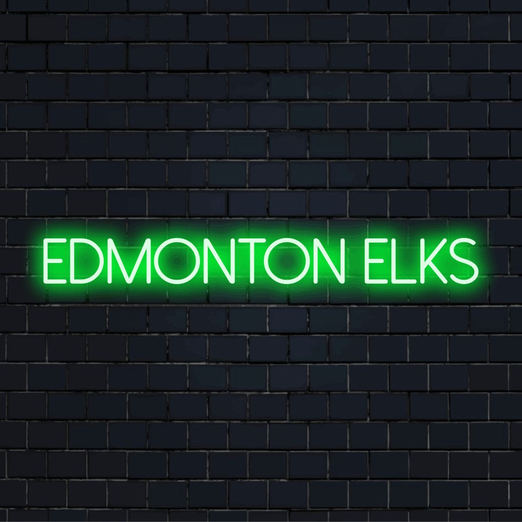 Edmonton Elks Neon Light with bright neon lettering on dark brick wall