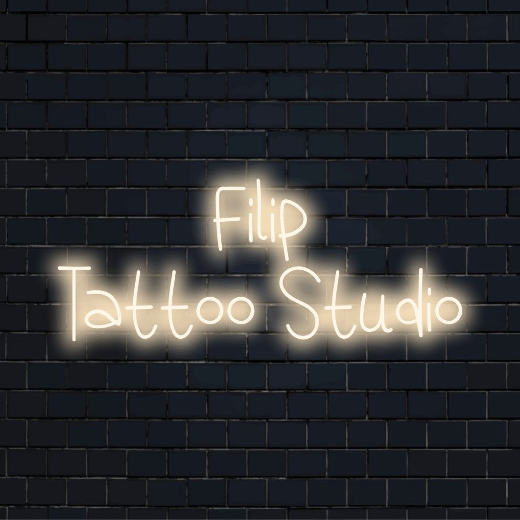 Filip Tattoo Studio Custom Name Neon Sign, neon text light against black brick wall