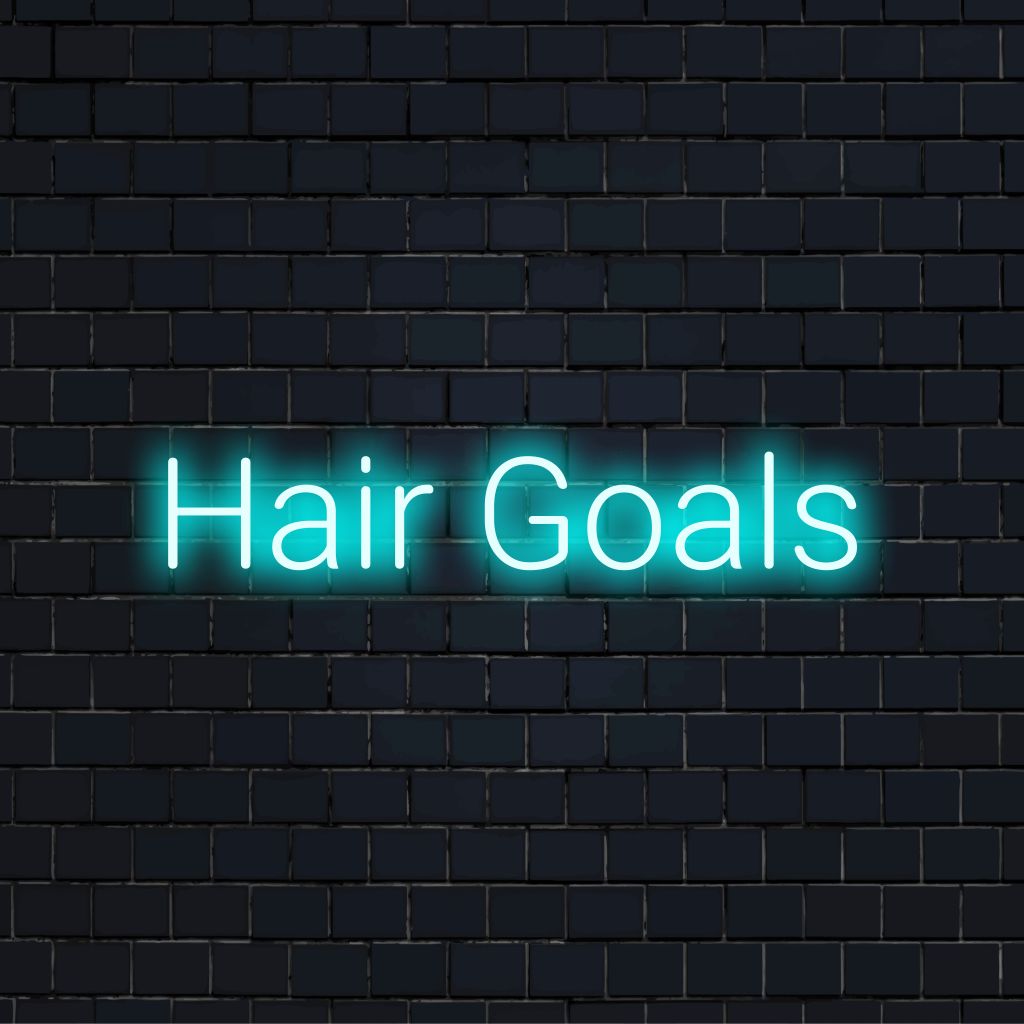Hair Goals Neon Light with bright neon glow against brick backdrop