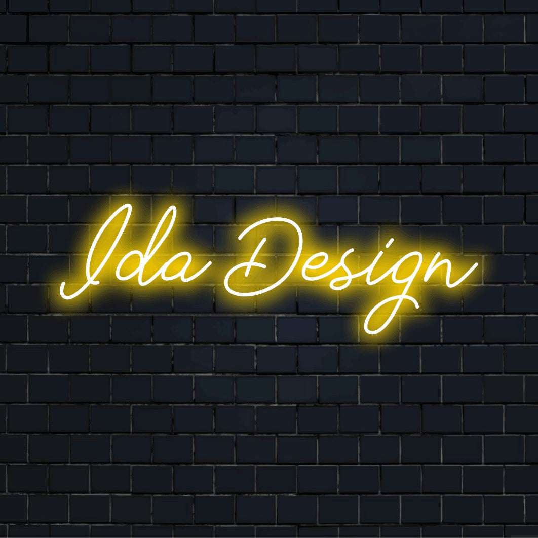 Ida Design Custom Name Neon Sign, glowing lettering on dark brick wall