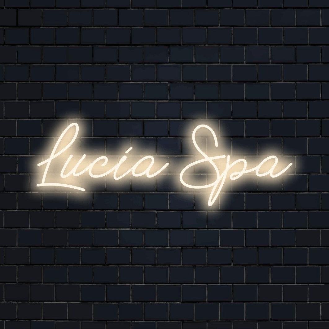 Lucia Spa Custom Name Neon Sign, bright LED glow on dark brick wall