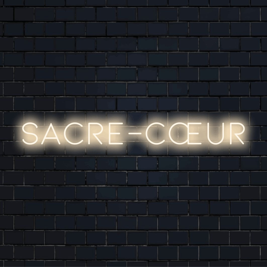 Sacre C Ur LED Neon Sign, bright LED glow on black brick background