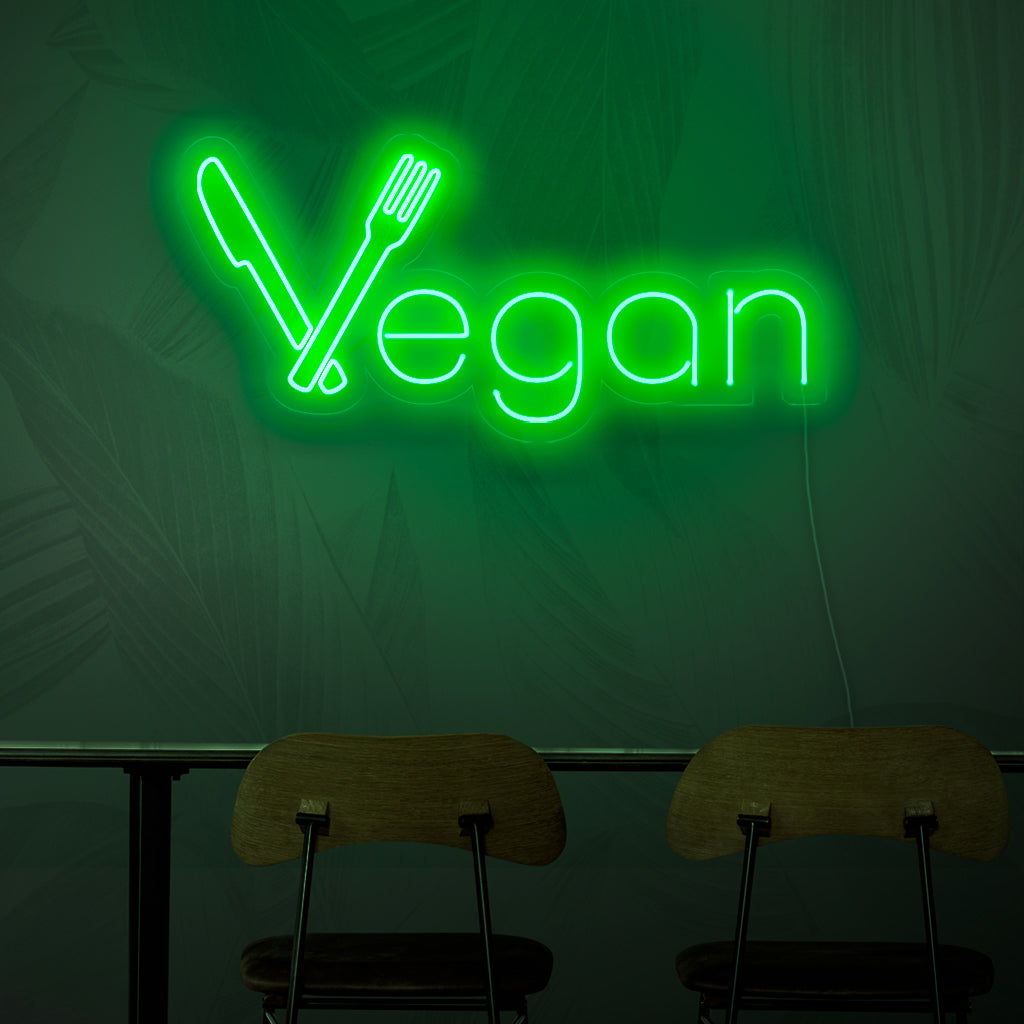 Een neonbord met de tekst 'Vegan', dat met zijn felgroene licht het concept van plantaardige keuken symboliseert.