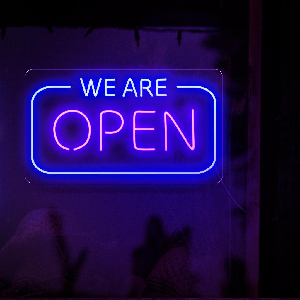 Een opvallend neonbord met de tekst 'We are Open' in opvallende, oplichtende letters. Dit geeft aan dat een bedrijf klaar staat om zijn klanten te bedienen.