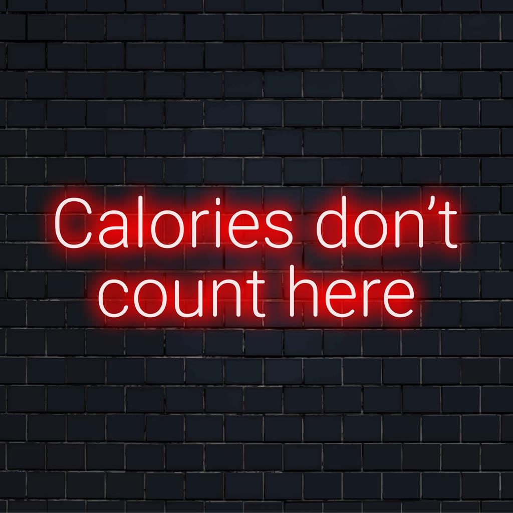 Een op maat gemaakt LED-neonbord met de tekst 'Calorieën tellen hier niet', ideaal om een ​​leuke, persoonlijke touch aan elke ruimte toe te voegen.