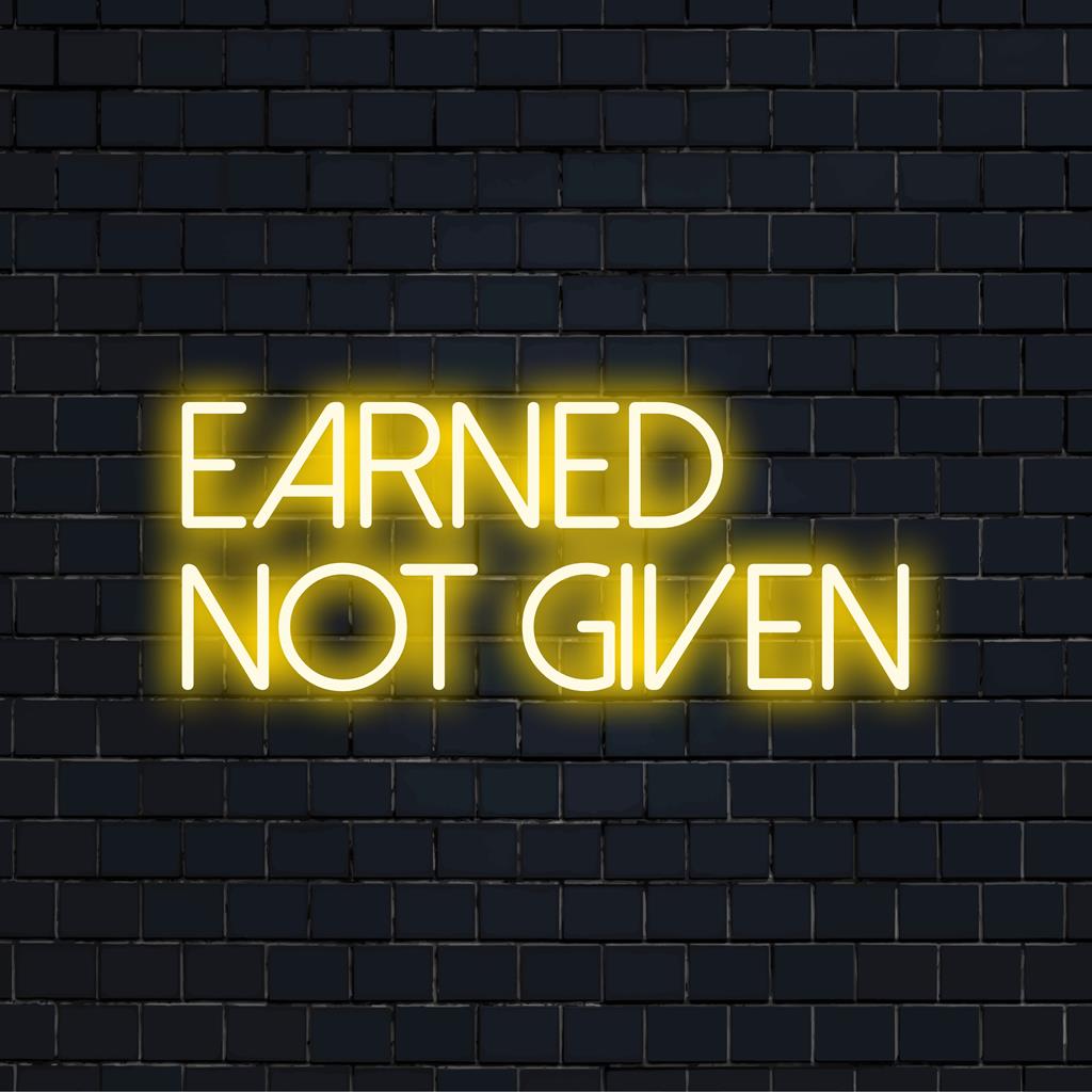 Op maat gemaakt LED-neonbord van het merk The Art Neon, met de inspirerende tekst Earned Not Given in levendige, oplichtende letters.