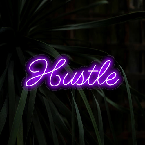 "Hustle Neon Sign" - Een motiverende toevoeging aan werkplekken, met het woord "Hustle" voor een vastberaden en hardwerkende sfeer, waardoor een geconcentreerde en stimulerende sfeer ontstaat.